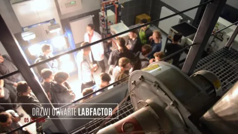 grupa studentów w laboratorium, na pierwszym planie ponad nimi widoczny jest wentylator